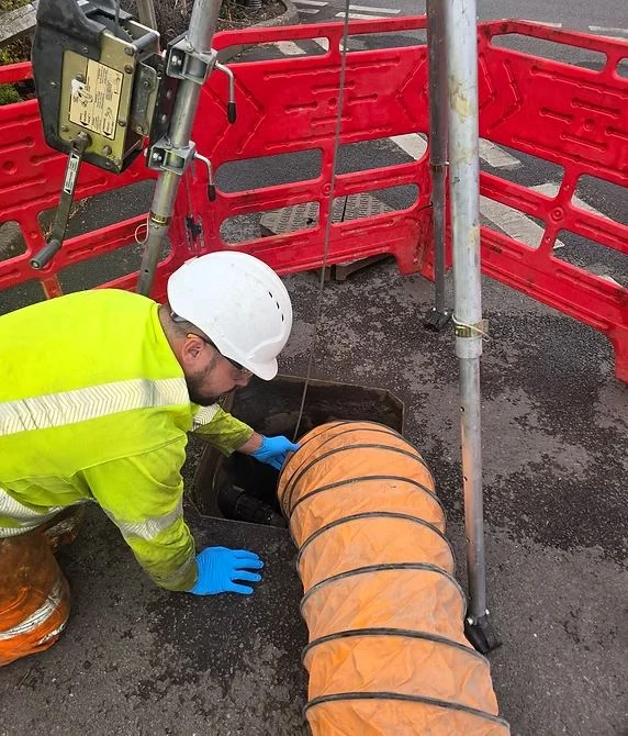Flux Sewer engineer preparing trenchless repair equipment on a residential street